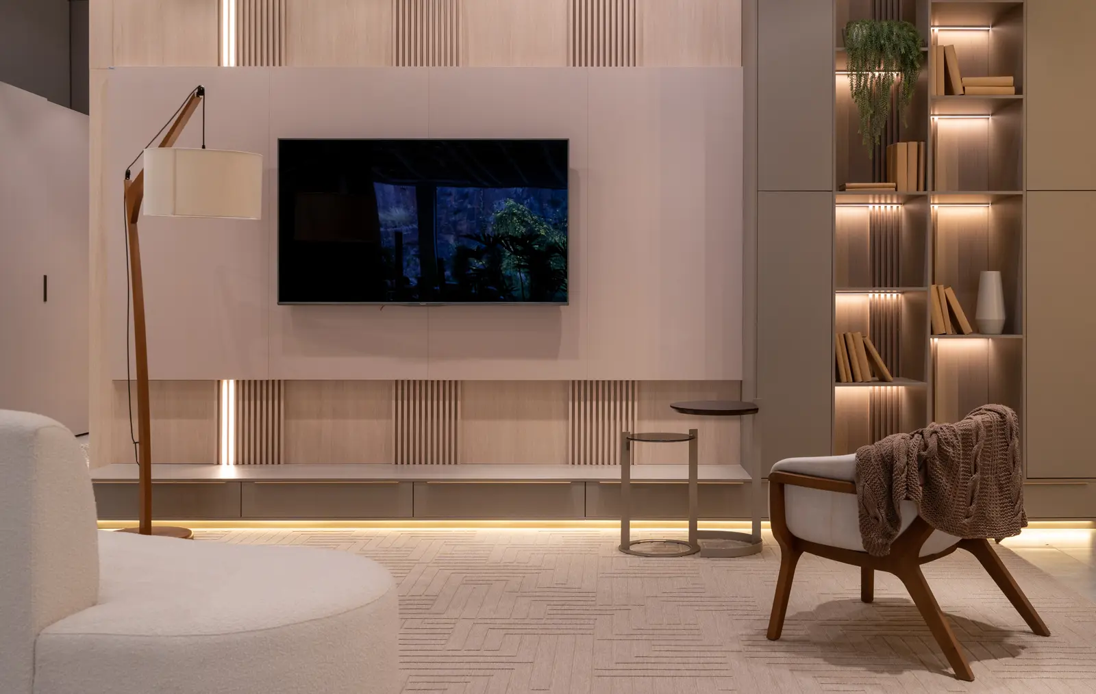 Sala de TV planejada Italínea em tons claros com painel ripado e estante iluminada — Sala com móveis planejados em Manaus