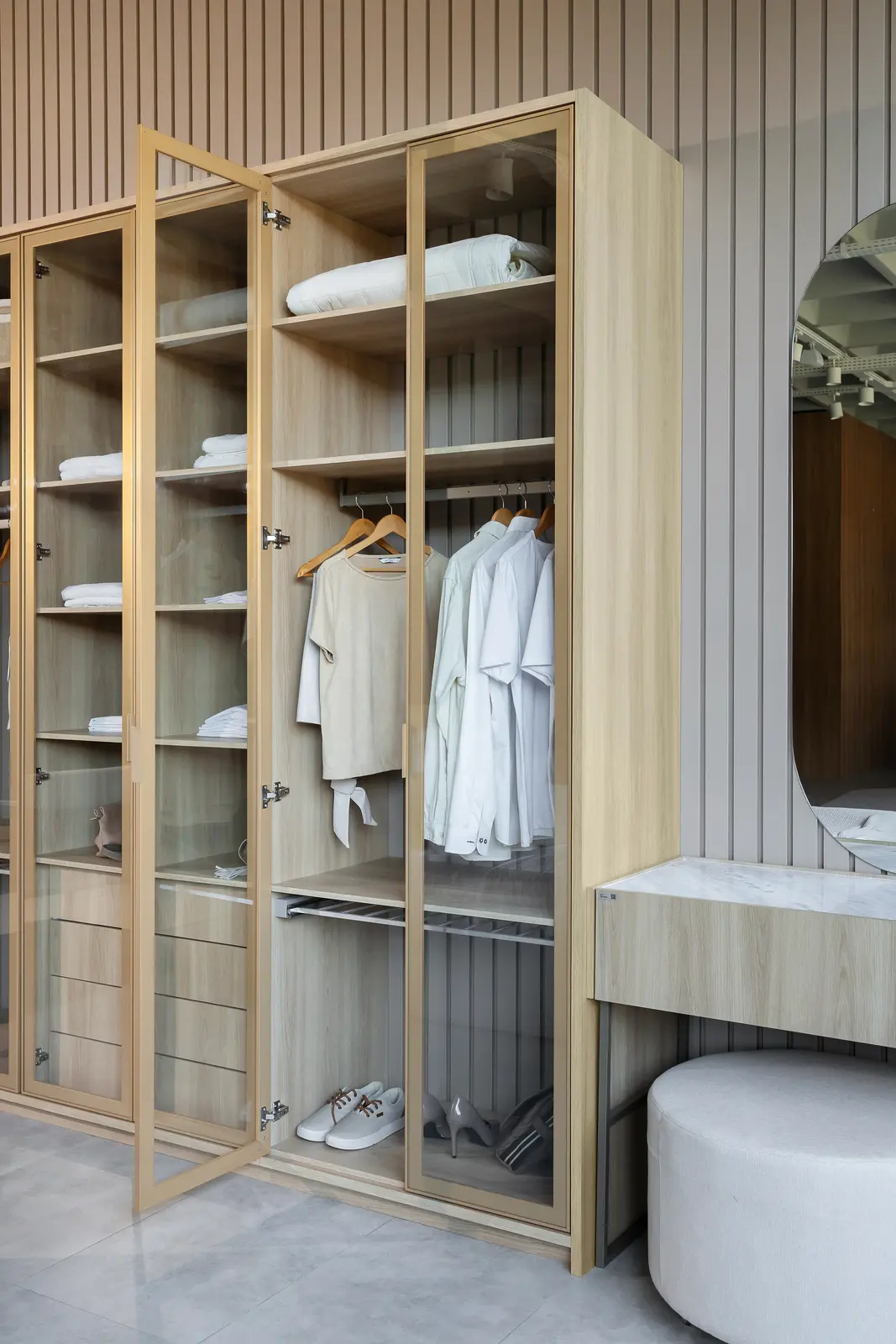 Closet planejado Italínea com portas de vidro, iluminação interna e armários amadeirados — Dormitório planejado Italínea em Manaus