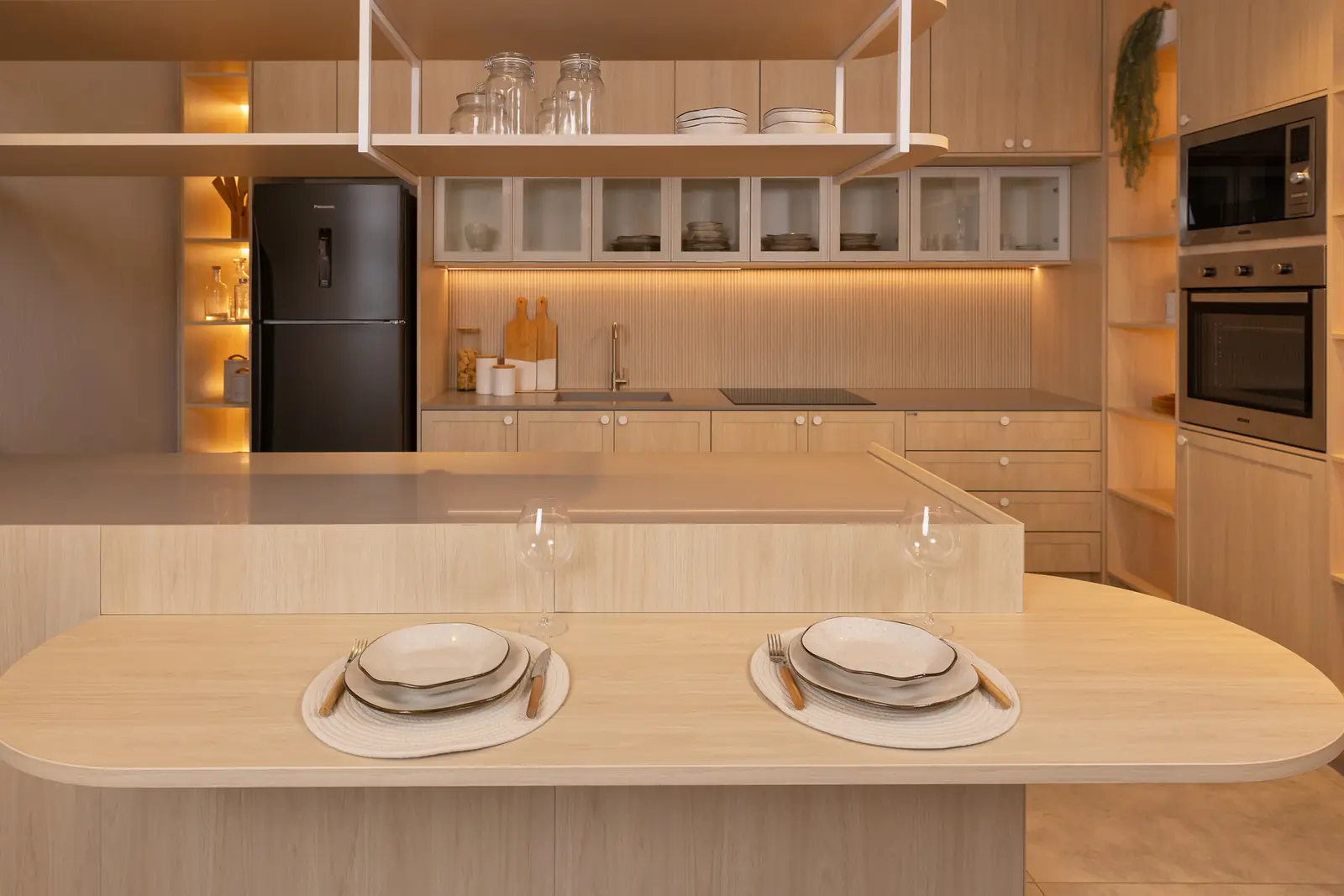 Cozinha planejada Italínea em madeira clara com ilha e mesa de refeições integrada — Cozinha planejada em Manaus com móveis sob medida