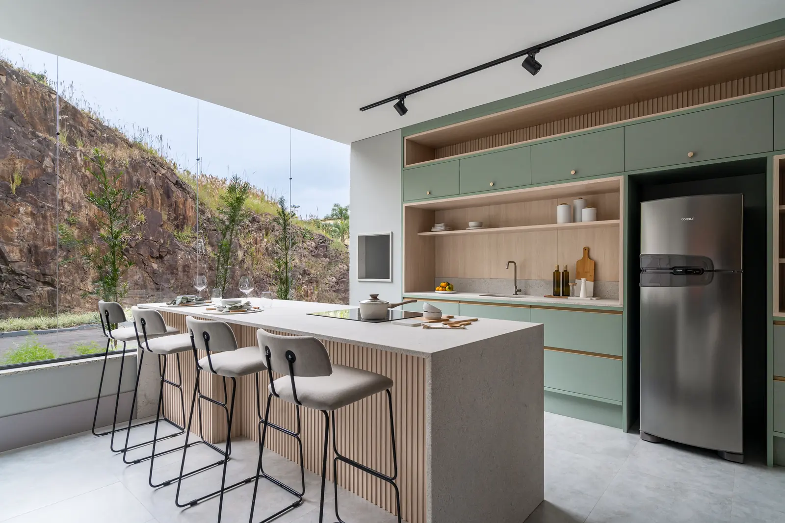 Cozinha planejada Italínea verde com ilha, banquetas e vista para área externa — Cozinha planejada em Manaus com móveis sob medida